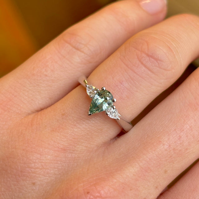Pear-cut teal sapphire & diamond three-stone engagement ring