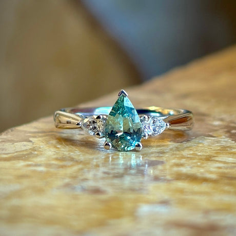 Pear-cut teal sapphire & diamond three-stone engagement ring