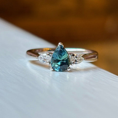 Pear-cut teal sapphire & diamond three-stone engagement ring