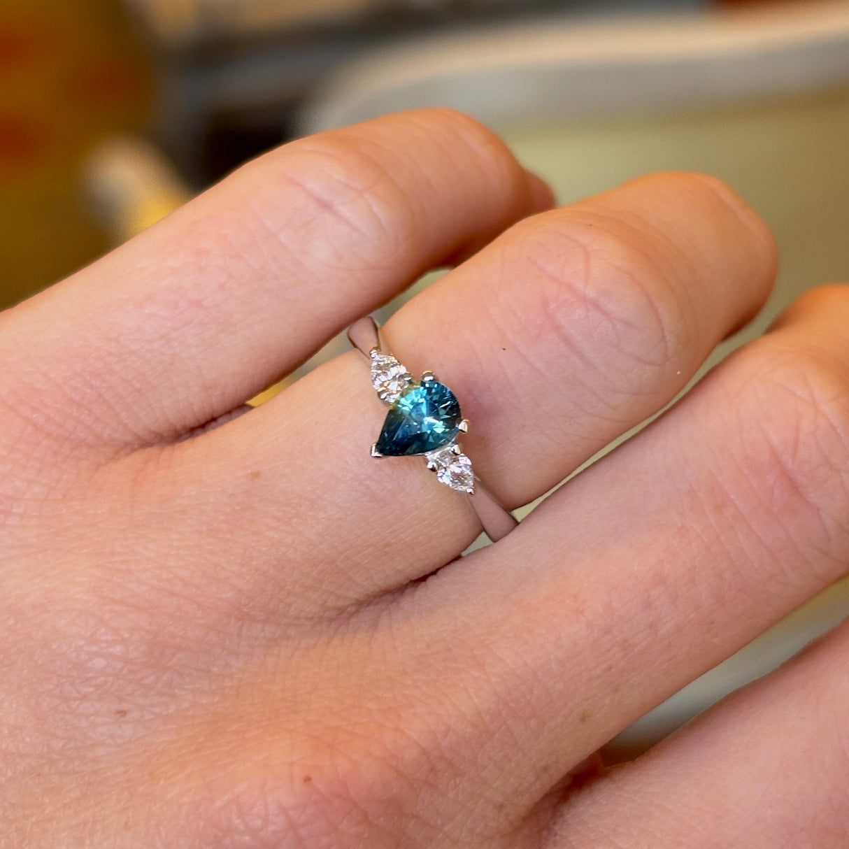 Pear-cut teal sapphire & diamond three-stone engagement ring