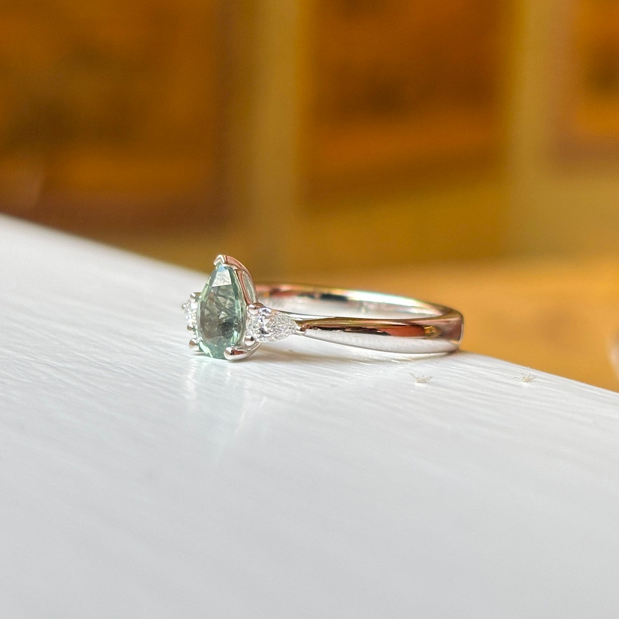 Pear-cut teal sapphire & diamond three-stone engagement ring