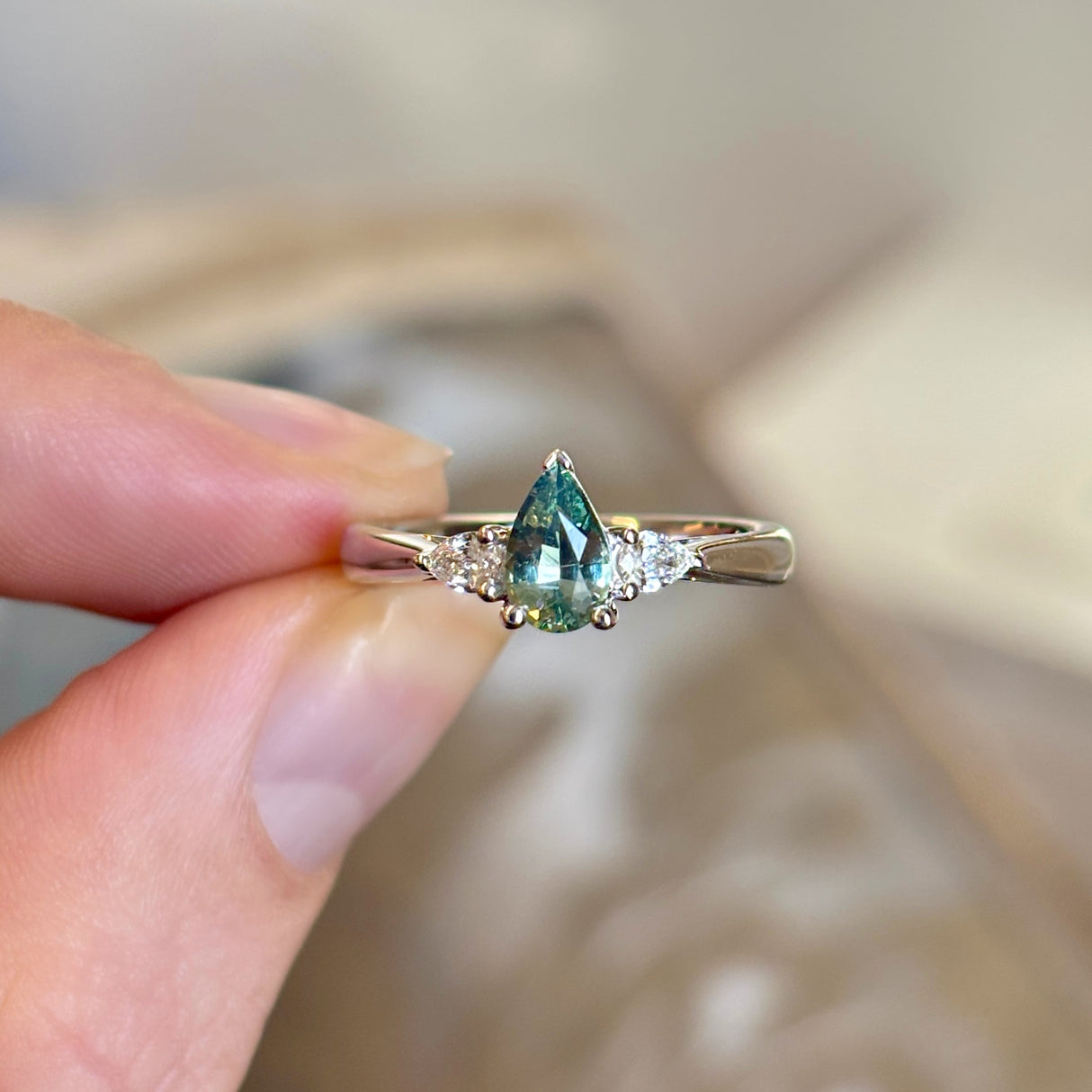 Pear-cut teal sapphire & diamond three-stone engagement ring