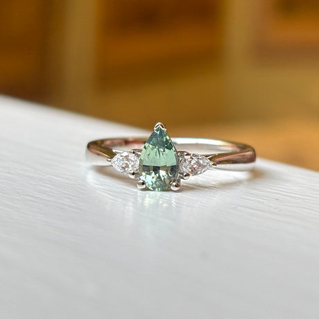 Pear-cut teal sapphire & diamond three-stone engagement ring