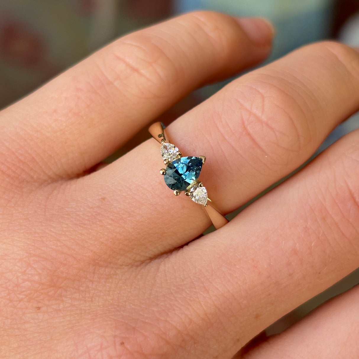 Pear-cut teal sapphire & diamond three-stone ring