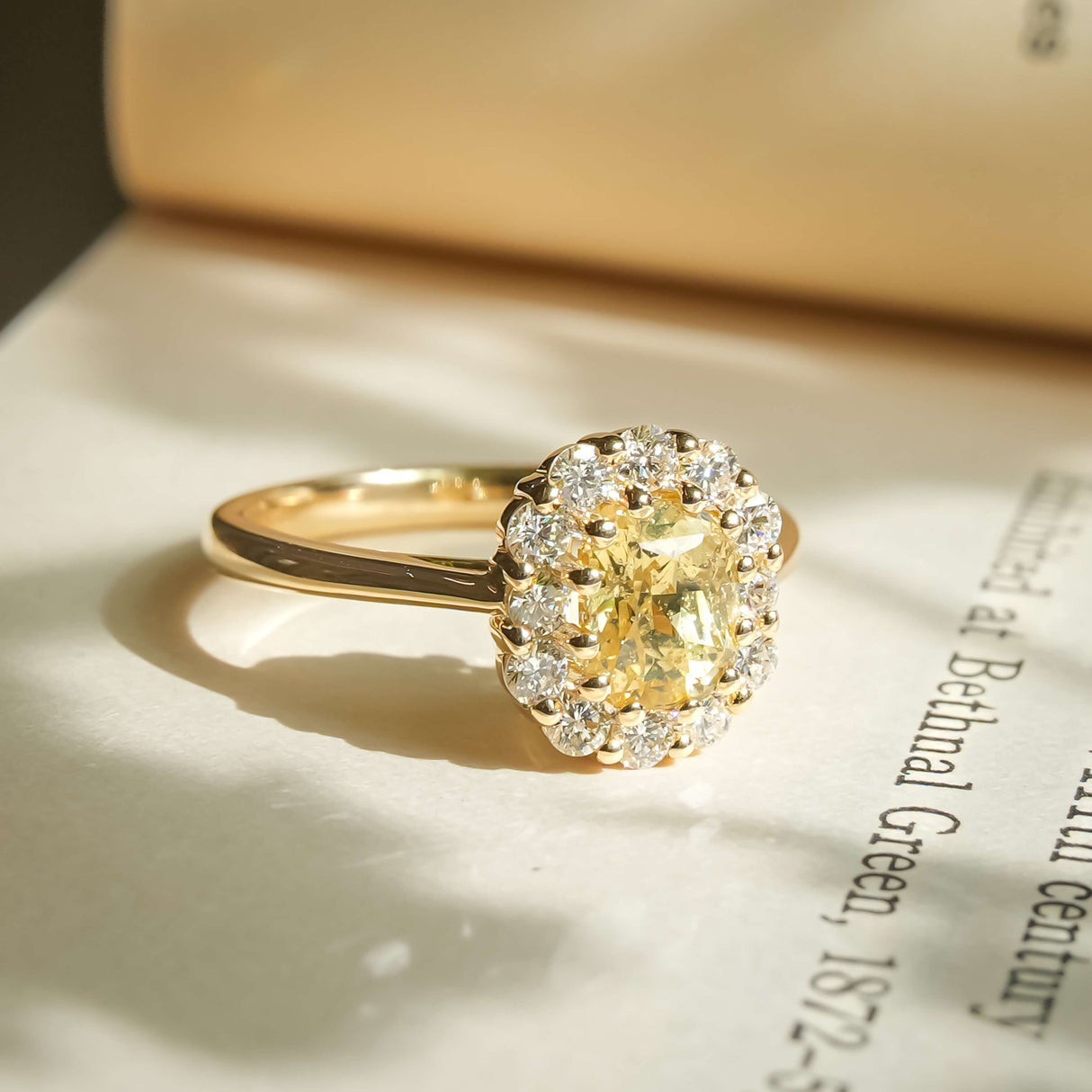 Oval yellow sapphire with diamond cluster halo engagement ring in yellow gold