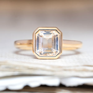An antique-inspired, pale yellow sapphire solitaire engagement ring in yellow gold.