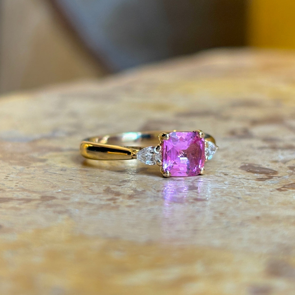 Pink sapphire and diamond three-stone engagement ring
