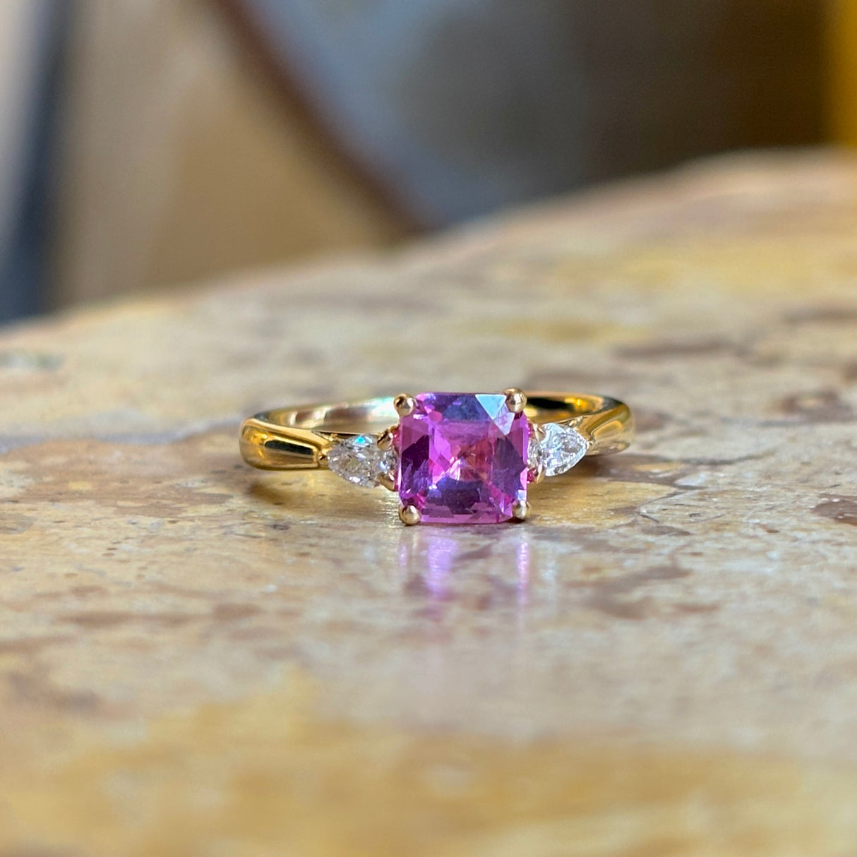 Pink sapphire and diamond three-stone engagement ring