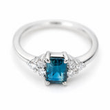 A platinum vintage-inspired, blue-green sapphire and diamond cluster trefoil engagement ring.