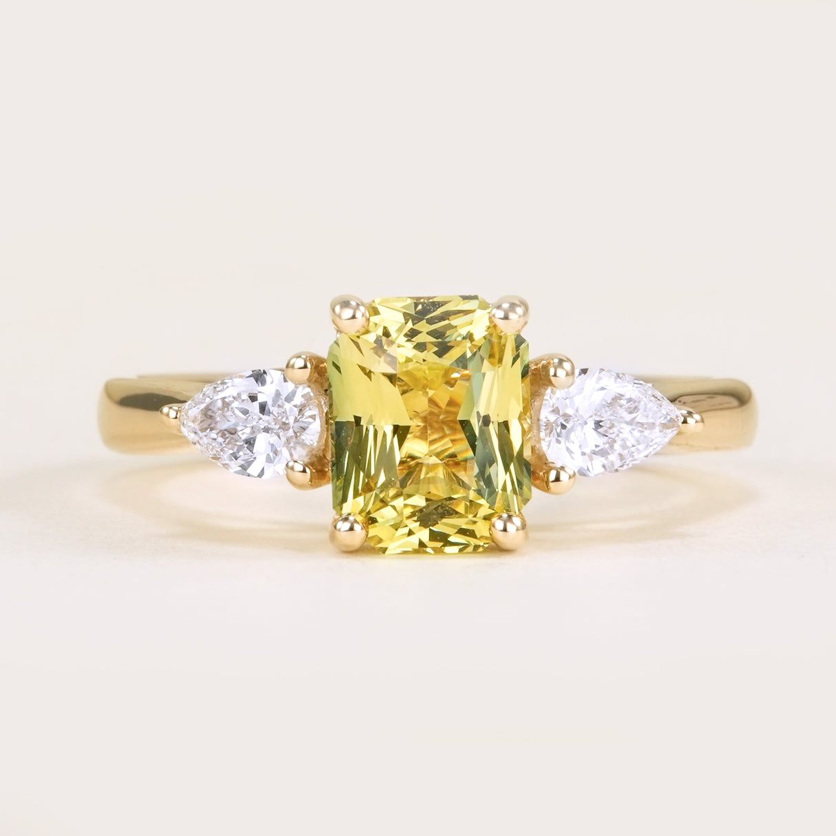 Emerald-cut yellow sapphire and diamond three-stone ring