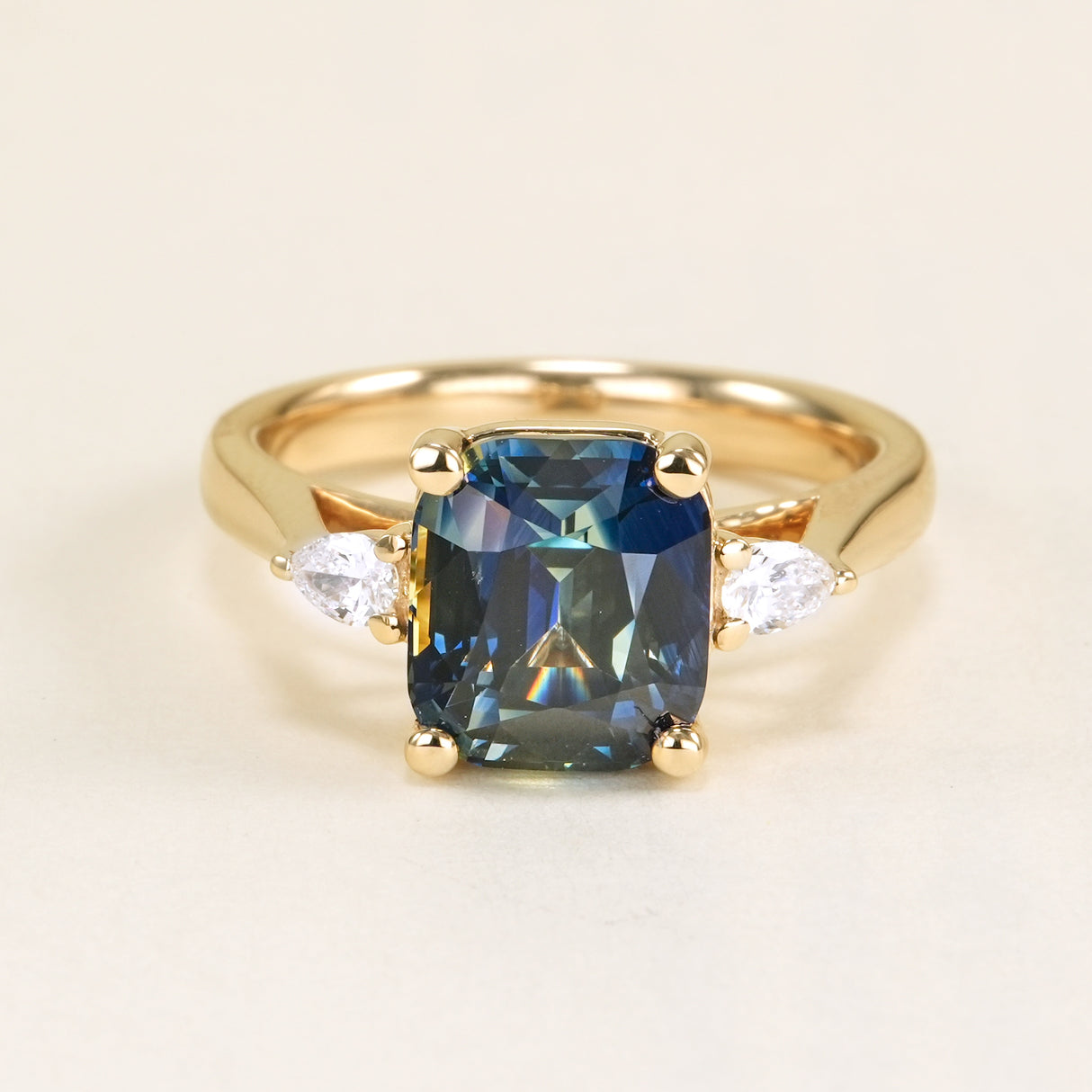 Colour-change cushion cut sapphire and diamond three-stone ring