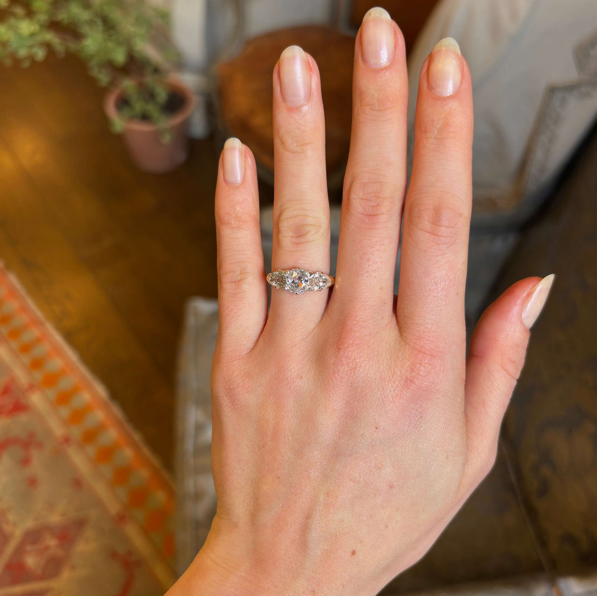 Antique Victorian three-stone with cushion-cut and pear-cut diamonds ring worn on ring finger captured on hand