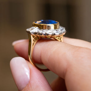 Side view of a vintage natural sapphire and diamond halo cluster ring highlighting the raised gallery and millegrain setting.