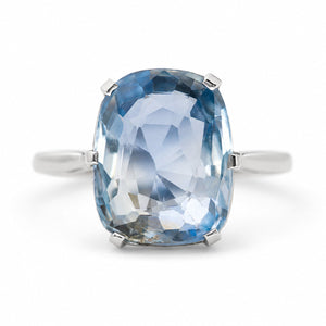 A cushion-cut light blue sapphire ring set in platinum, shown against a plain white background.