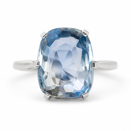 A cushion-cut light blue sapphire ring set in platinum, shown against a plain white background.