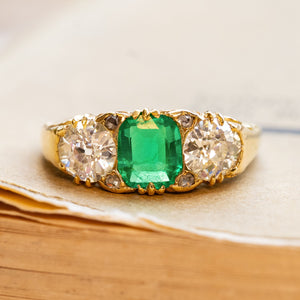 Antique Victorian emerald and diamond three-stone ring in yellow gold.