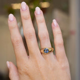 An antique Victorian colour-change sapphire gypsy ring worn on the hand.