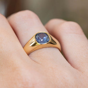 Close-up of an antique Victorian colour-change blue-purple sapphire gypsy ring in yellow gold.