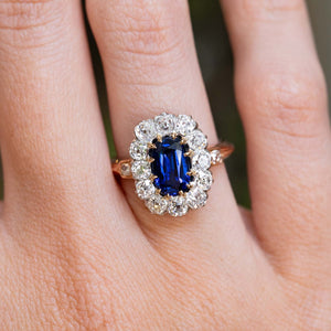 An antique Jugendstil royal-blue sapphire and diamond cluster ring worn on the finger.