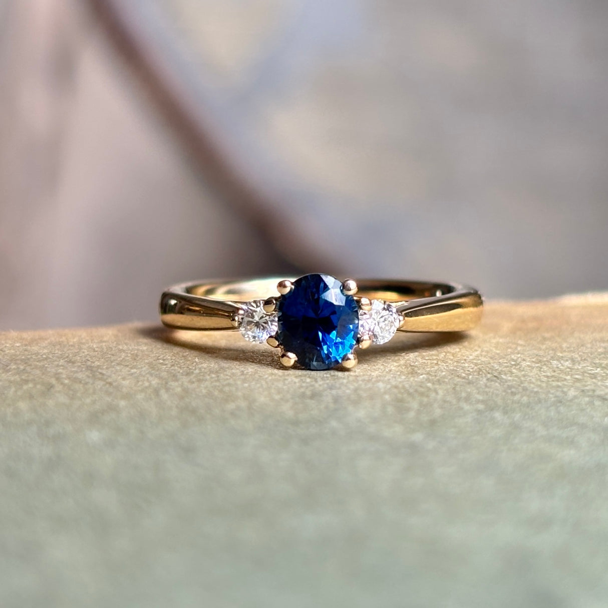 Blue sapphire and diamond three-stone engagement ring