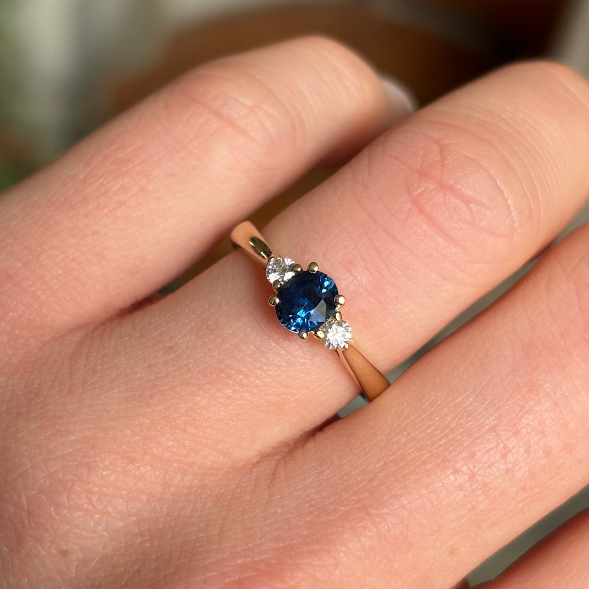 Blue sapphire and diamond three-stone engagement ring