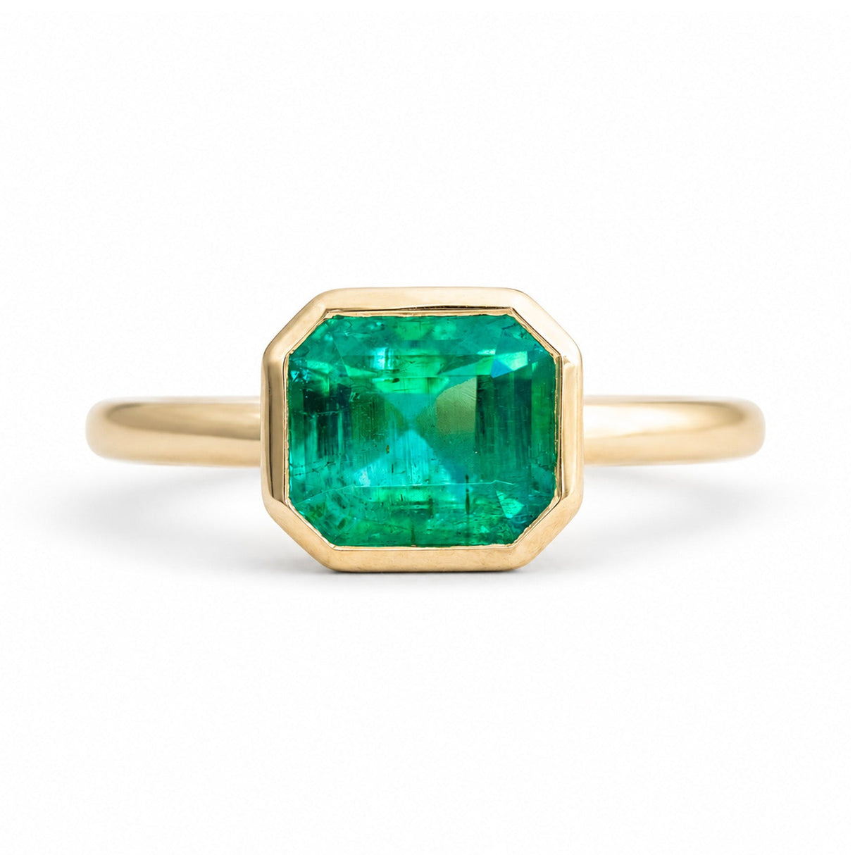 An antique-inspired, Emerald solitaire engagement ring set in 14ct yellow gold.