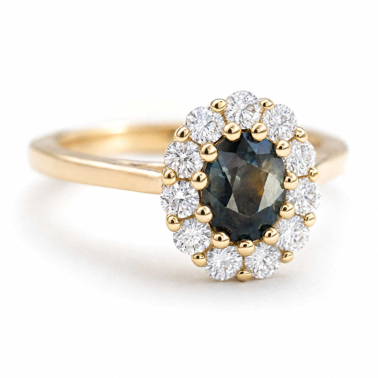 A vintage-inspired yellow gold engagement ring with a deep green sapphire and diamond halo.
