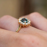 Side detail of an antique-inspired teal sapphire and diamond cluster engagement ring in 14ct yellow gold.