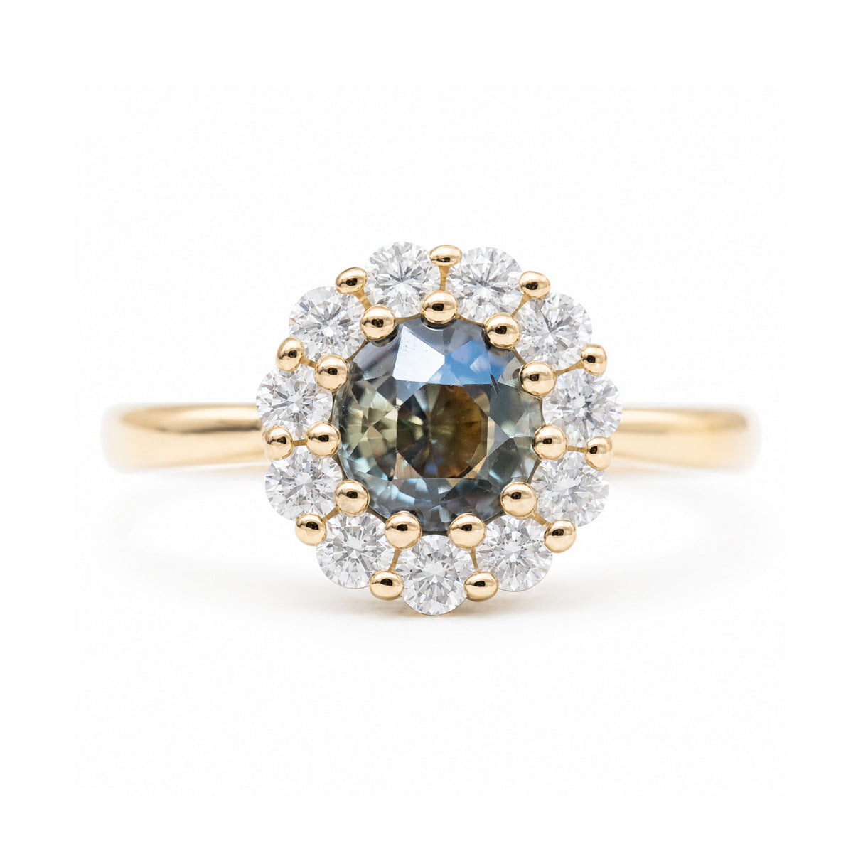 Antique-inspired earthy green sapphire and diamond halo engagement ring in yellow gold.