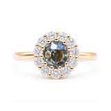 Antique-inspired earthy green sapphire and diamond halo engagement ring in yellow gold.