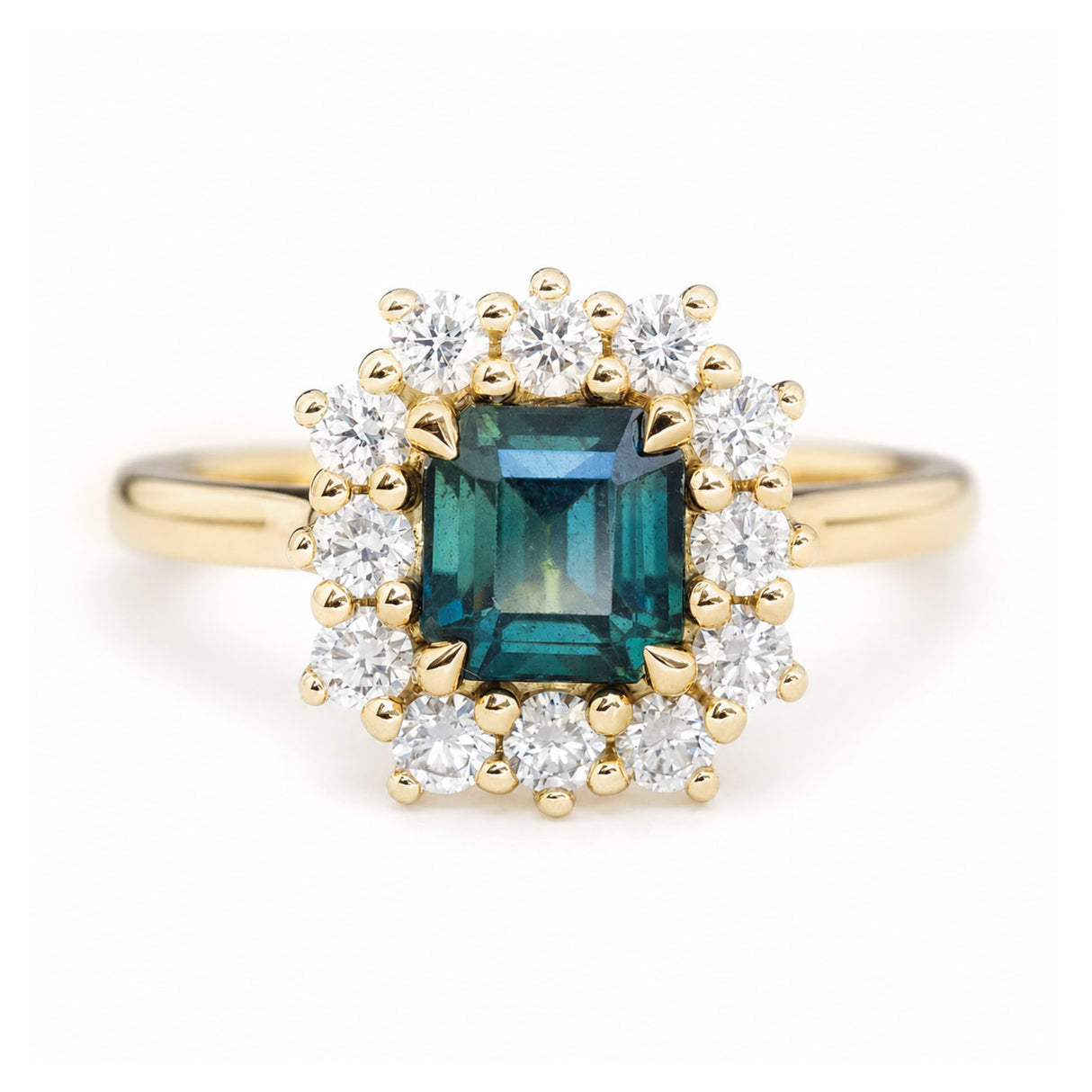 A close-up photo of an antique-inspired, teal sapphire and diamond cluster engagement ring in yellow gold.