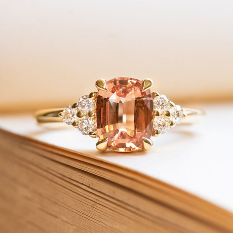 A vintage-inspired, orange sapphire & diamond tre-foil yellow gold engagement ring.