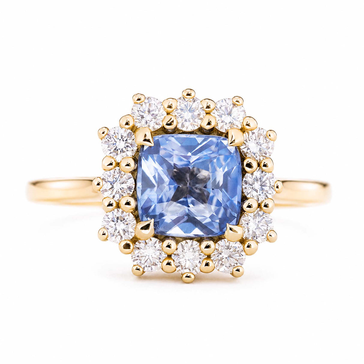 An antique-inspired, blue sapphire and diamond halo cluster engagement ring set in 14ct yellow gold.