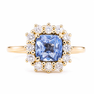 An antique-inspired, blue sapphire and diamond halo cluster engagement ring set in 14ct yellow gold.