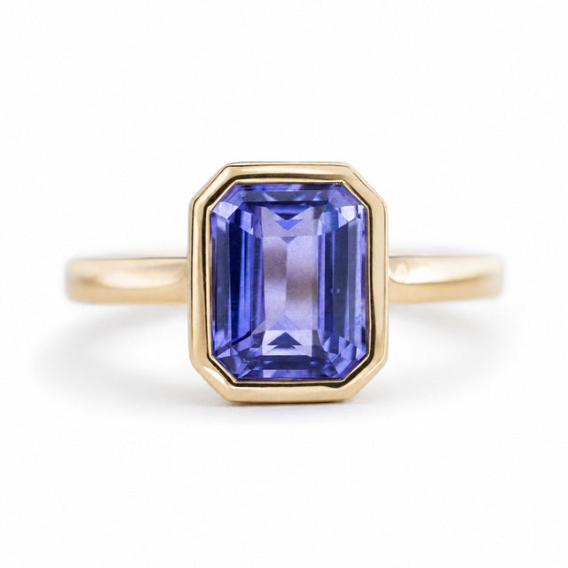 An antique-inspired bright indigo-blue sapphire solitaire engagement ring in yellow gold.