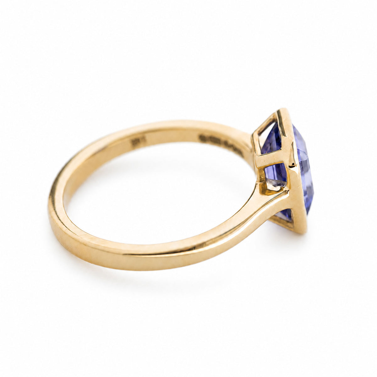 The side profile of an antique-inspired blue sapphire solitaire engagement ring in 14ct yellow gold.