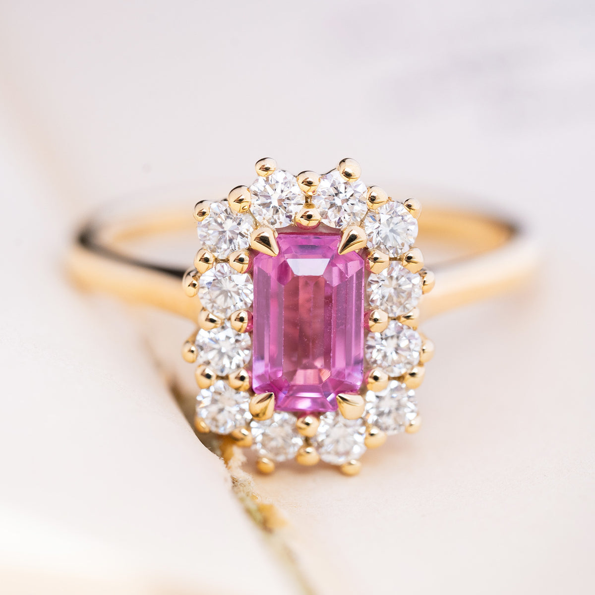 An antique-inspired, pink sapphire and diamond cluster engagement ring in 14ct yellow gold. 