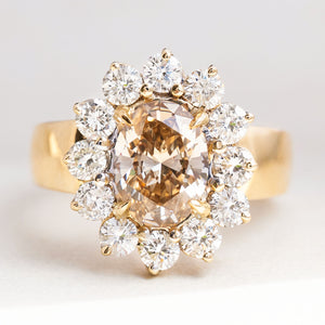 Vintage 1980s fancy coloured brown diamond cluster ring featuring an oval brown diamond surrounded by a sparkling cluster of brilliant-cut white diamonds in yellow gold.