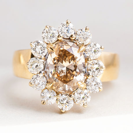 Vintage 1980s fancy coloured brown diamond cluster ring featuring an oval brown diamond surrounded by a sparkling cluster of brilliant-cut white diamonds in yellow gold.