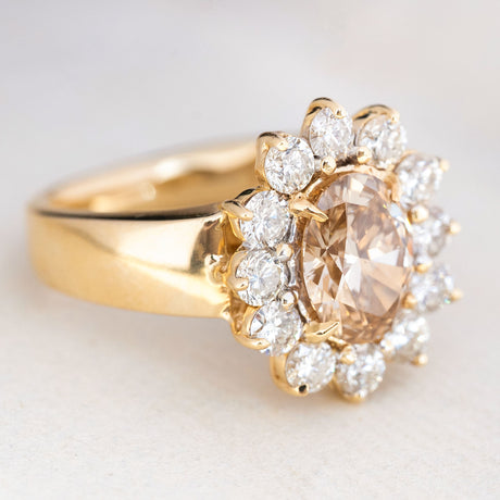 Vintage brown diamond cocktail ring with an oval fancy coloured brown diamond framed by a halo of brilliant-cut diamonds.