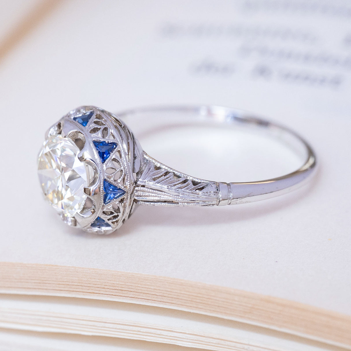 Antique, Art Deco diamond and sapphire cluster ring in white gold and platinum with an Egyptian style motif. 