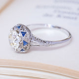 Antique, Art Deco diamond and sapphire cluster ring in white gold and platinum with an Egyptian style motif. 