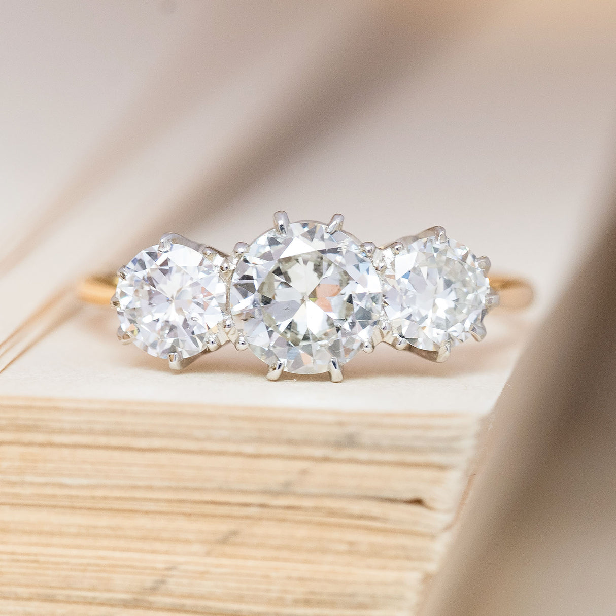An antique, Edwardian old-cut diamond three-stone ring with 18ct yellow gold and platinum.