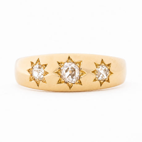 An antique, Edwardian diamond three-stone gypsy ring in yellow gold. 