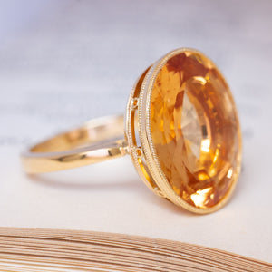 A vintage cocktail ring with an orange topaz in yellow gold.