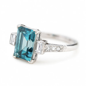 A three-quarter close-up of an antique, Art Deco 1920s blue zircon & diamond ring in platinum.