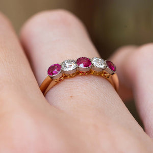 Side view of an antique Edwardian ruby and old-cut diamond five-stone ring worn on the finger.