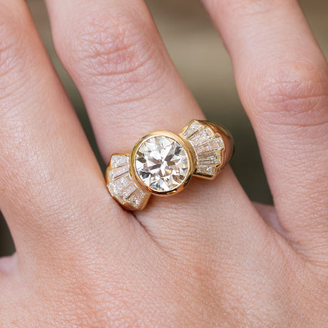Vintage 1950s old-cut diamond fan engagement ring shown on the finger, highlighting the old-cut diamond and tapered baguette diamond fan design.