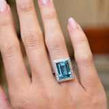 An antique Art Deco aquamarine and diamond cocktail ring in platinum worn on the hand.