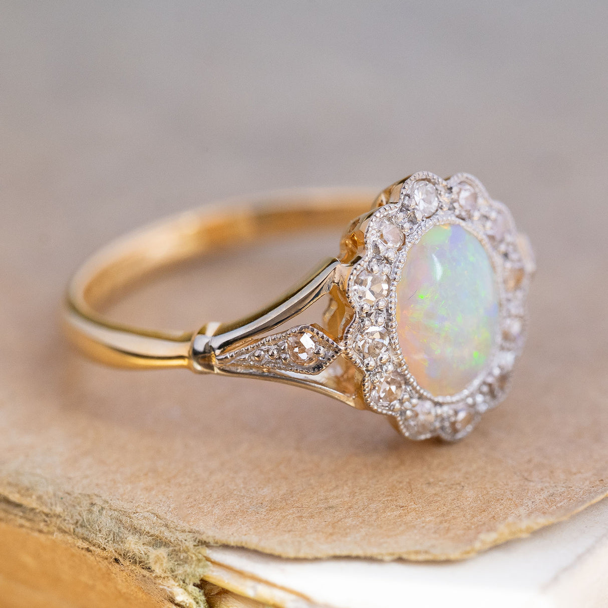 An antique, Edwardian opal & diamond cluster ring in yellow gold and platinum showing the details on the shoulder.